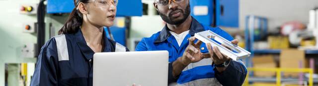 Two people looking over a device.